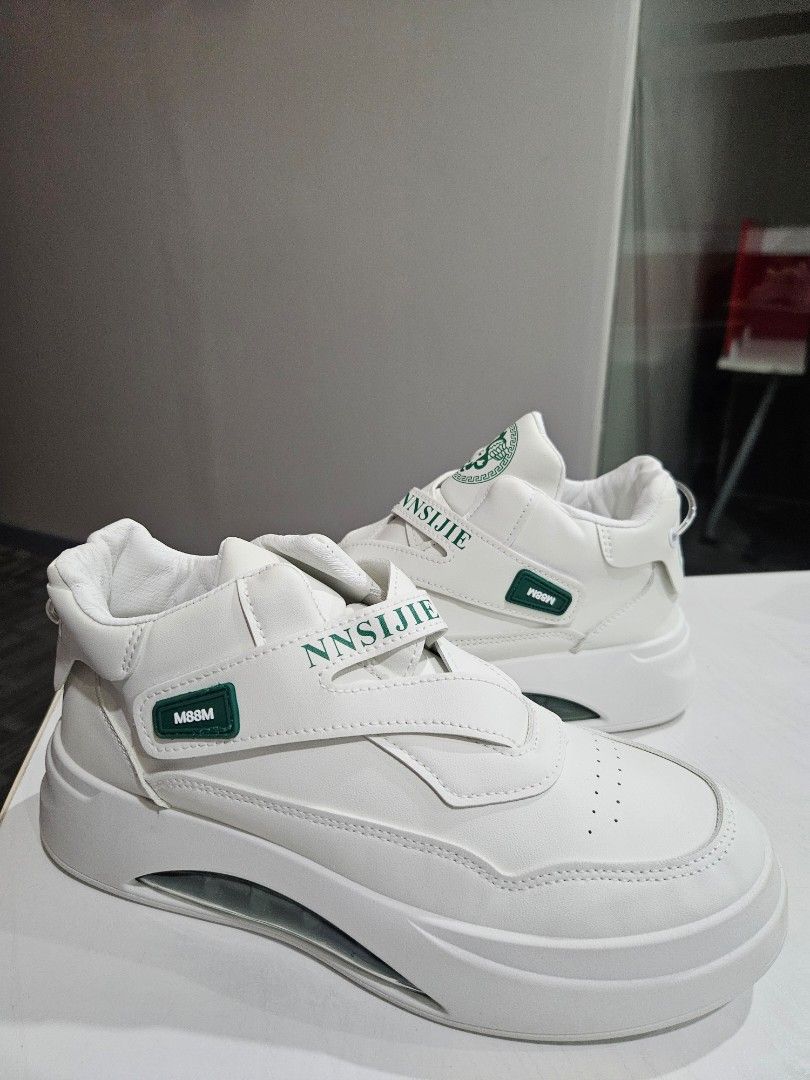 NNSIJIE White Sneakers (Category: Sneakers) located in Manila. Submitted by honeypatch (Listing ID 1421223957, Image 1). Description: - White sneakers with a unique design - Features a strap with "NNSIJIE" branding - Visible air cushion sole - Green accent on the strap - Versace like logo on the tongue - Thick sole for added comfort and style - RFS: Originally bought for Monito Monita but recipient went AWOL so Im selling it instead. - Brand New 