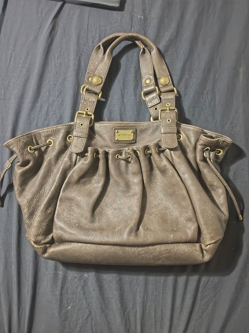 Patrick Cox Brown Leather Handbag | city bag (Category: Luxury Bags & Wallets) located in Makati City. Submitted by elirei (Listing ID 1421266658, Image 1). Description: - Patrick Cox brown leather handbag - Drawstring closure - Adjustable straps with buckle details - Interior zippered pocket with brand logo - Textured leather exterior - Dark fabric lining - Multiple compartments -Thick leather -Quite heavy Has sign of usage, ends rubs negotiatia