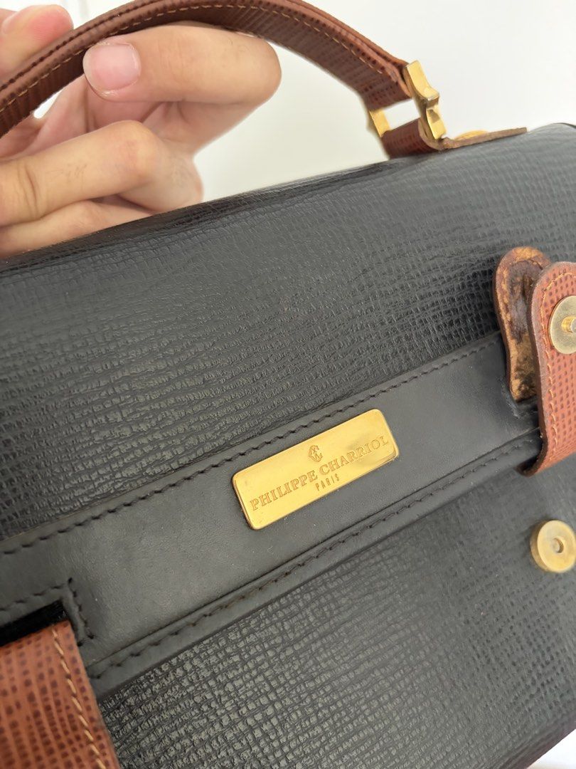 Philippe Charriol Black Handbag (Category: Luxury Bags & Wallets) located in Makati City. Submitted by lenyfelix (Listing ID 1421195665, Image 3). Description: - Philippe Charriol black handbag - Top handle - Flap closure with gold-tone clasp - Brown leather accents - Textured exterior - Gold-tone brand plaque - Minor wear on leather accents - see flaws in photo.