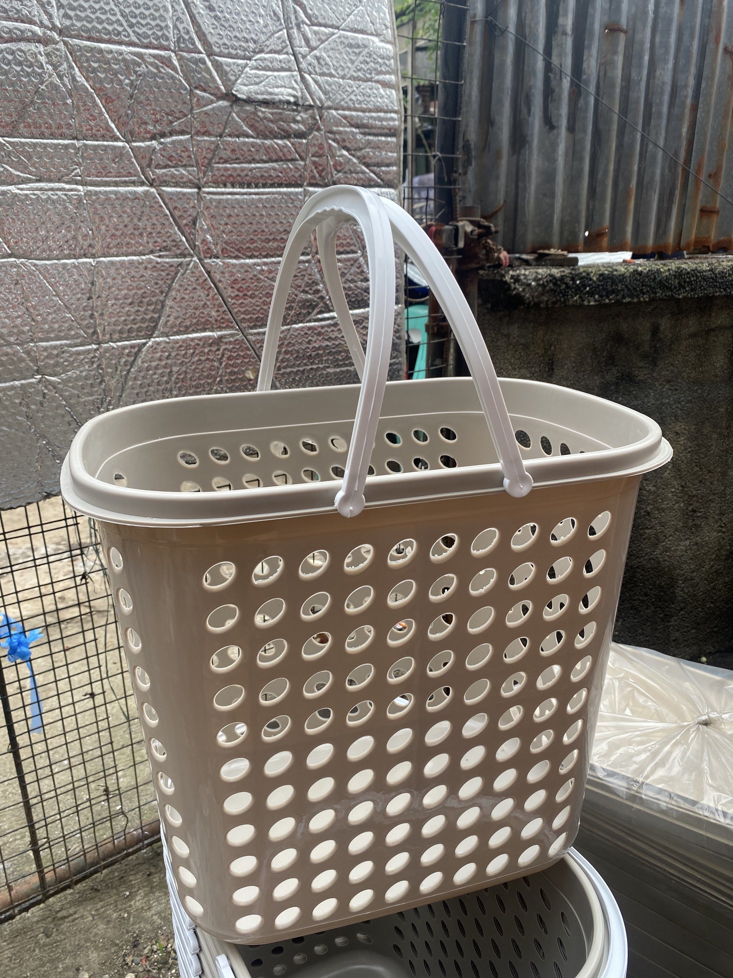 Plastic Laundry Basket with Handles (Category: Laundry Baskets) located in Caloocan City. Submitted by brightdeer.83db1b (Listing ID 1421145988, Image 1). Description: - Durable beige plastic laundry basket - Rectangular shape with rounded corners - Features ventilation holes - Two sturdy white handles - Ideal for laundry storage.