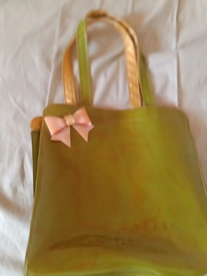 Ted Baker London Green Handbag (Category: Luxury Bags & Wallets) located in Bacoor. Submitted by luxe1820 (Listing ID 1421177558, Image 1). Description: - Green Ted Baker London handbag - Features a bow detail - Gold-colored interior - Gold handles with wear - Glossy finish.