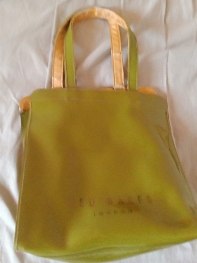 Ted Baker London Green Handbag (Category: Luxury Bags & Wallets) located in Bacoor. Submitted by luxe1820 (Listing ID 1421177558, Image 3). Description: - Green Ted Baker London handbag - Features a bow detail - Gold-colored interior - Gold handles with wear - Glossy finish.