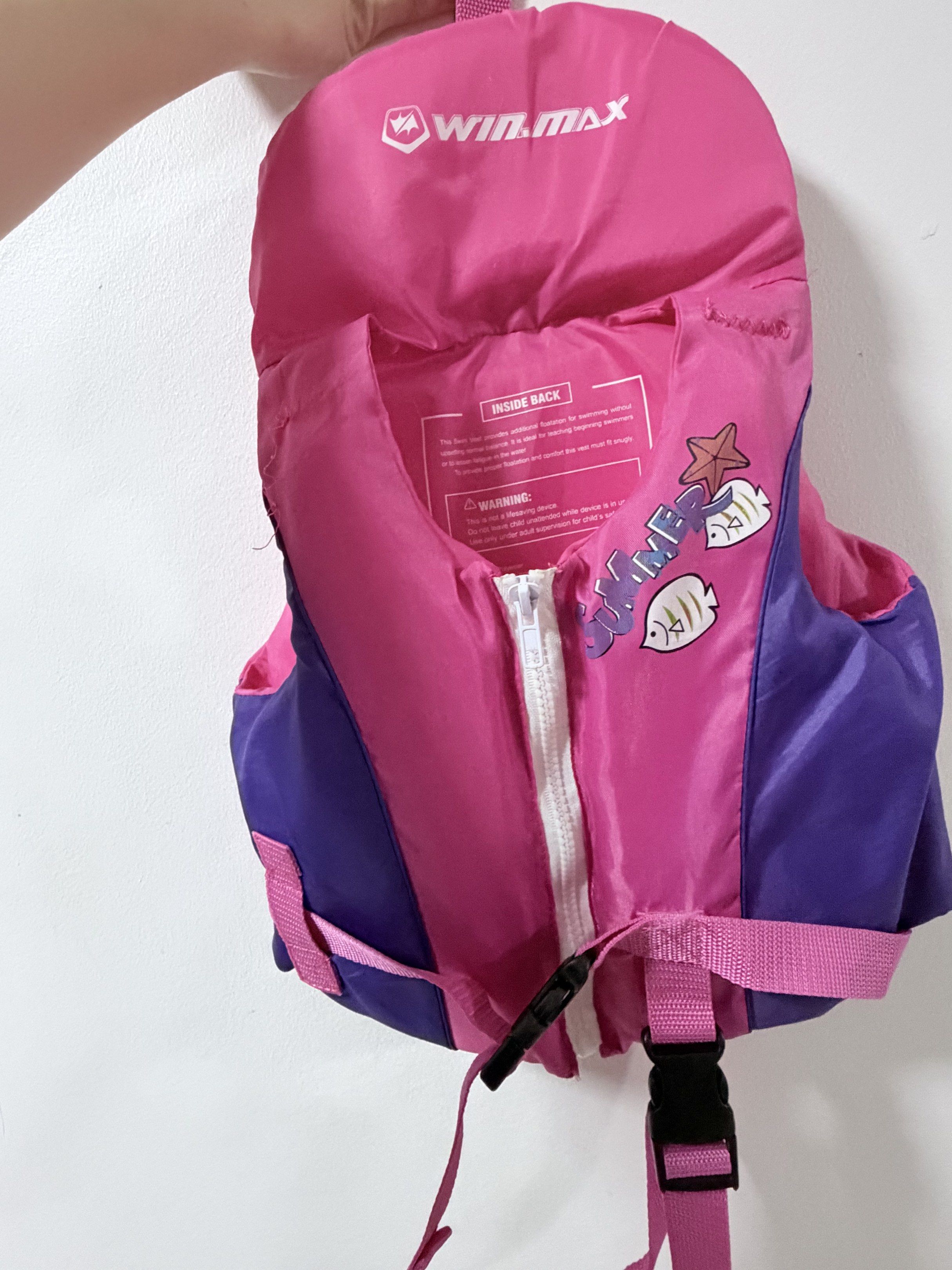 Winmax Pink Life Vest/Jacket for Toddlers (Category: Vests) located in Pasig City. Submitted by iammr.owl29 (Listing ID 1421143184, Image 1). Description: Item condition: - Winmax life vest for water activities. - Vibrant pink and purple color. - Secure zipper and adjustable straps. - Fun starfish and fish graphics. - Designed for buoyancy and safety. - Made of durable material. - Includes a loop for hanging. Disclaimers: ❕Actual color may vary d