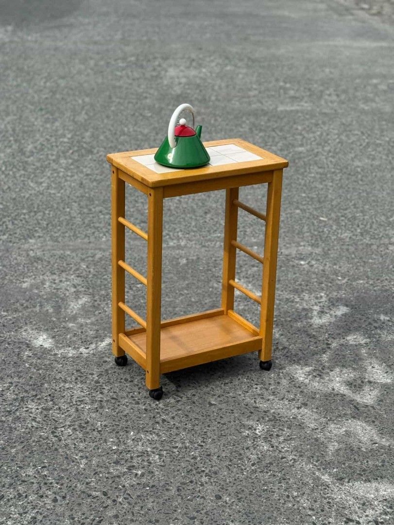 Wooden Side Table with Tile Top (Category: Tables & Sets) located in Manila. Submitted by upcycle_things (Listing ID 1421194234, Image 3). Description: Wooden side table features a tiled top and a lower shelf for storage. It has a warm, natural wood finish and is mounted on wheels for easy movement. The table has a simple, functional design, perfect for small spaces. It's ideal for use as a bedside table or a small side table in a living room..