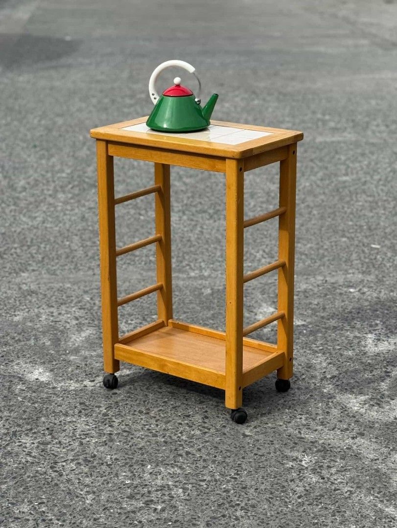 Wooden Side Table with Tile Top (Category: Tables & Sets) located in Manila. Submitted by upcycle_things (Listing ID 1421194234, Image 2). Description: Wooden side table features a tiled top and a lower shelf for storage. It has a warm, natural wood finish and is mounted on wheels for easy movement. The table has a simple, functional design, perfect for small spaces. It's ideal for use as a bedside table or a small side table in a living room..