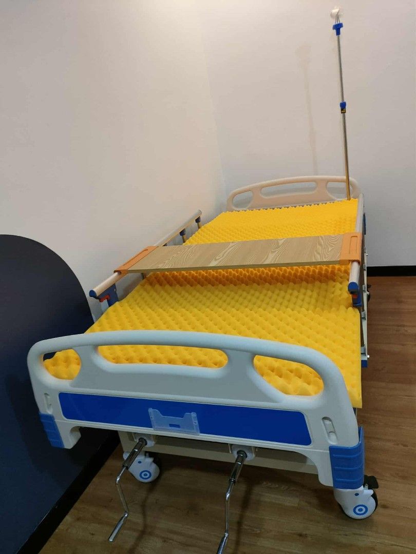 Adjustable Hospital Bed with Mattress (Category: Bed Frames & Mattresses) located in Quezon City. Submitted by medicsupplies_09 (Listing ID 1421329576, Image 2). Description: - Adjustable hospital bed - Includes bed and egg mattress - Features a wooden tray - Equipped with wheels for easy mobility - Side rails for added safety - Comes with an IV pole - White and blue frame.