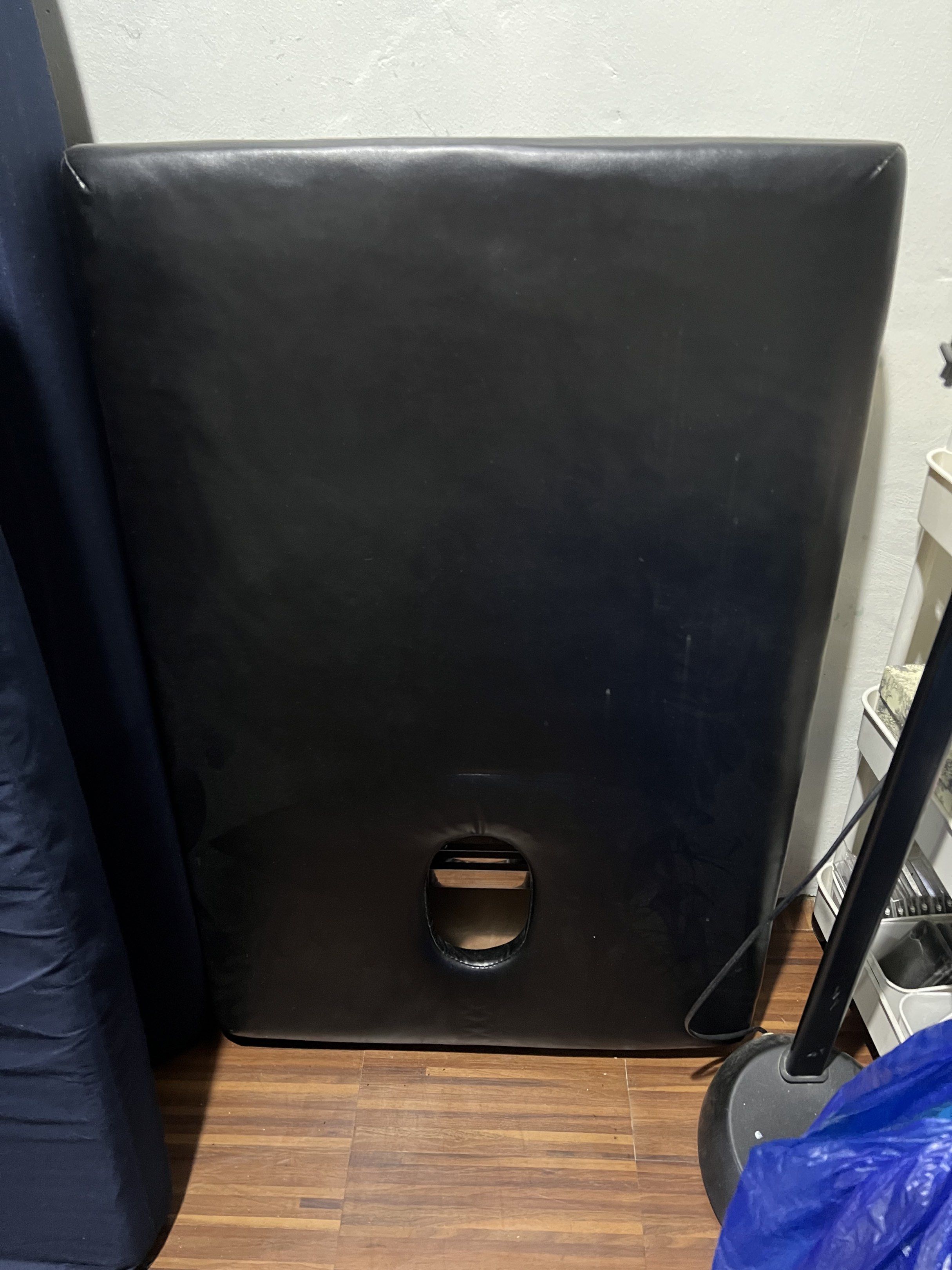 Black Massage Table (Category: Massage Devices) located in Caloocan City. Submitted by chinchellie (Listing ID 1421393926, Image 1). Description: - Black massage table - Includes face cradle cutout - Made of smooth, leather-like material - Rectangular shape with rounded corners - Minor marks on the surface.