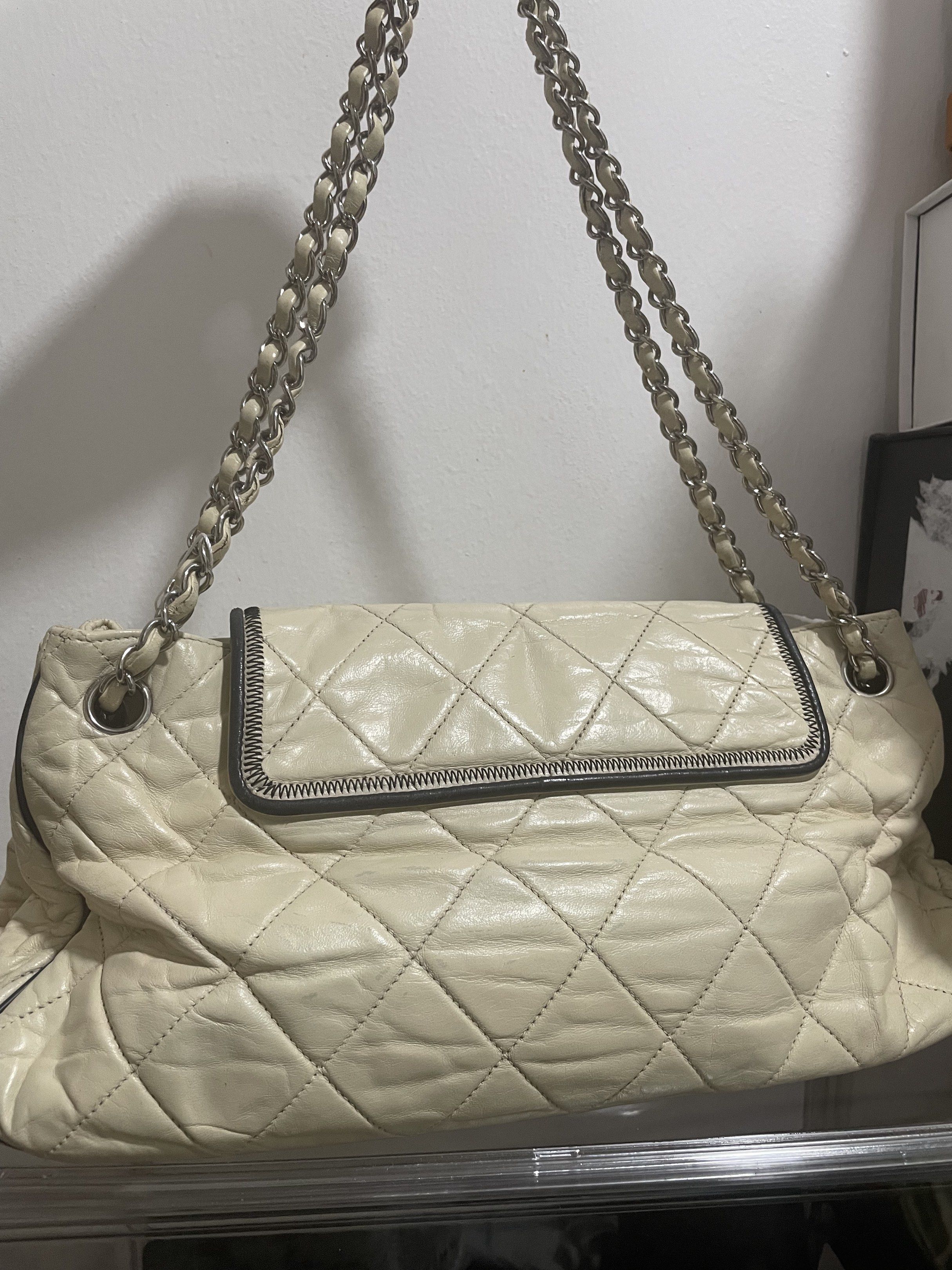 Chanel Accordion Reissue Flap Bag (Category: Luxury Bags & Wallets) located in Davao. Submitted by prettythings.ph (Listing ID 1421434839, Image 2). Description: Authentic Chanel Accordion Reissue Flap Bag in cream color. Features a quilted design with a silver chain strap. The bag has a metal clasp closure with the Chanel logo. Includes an authenticity certificate from LegitGrails. The interior has a Chanel logo and a serial number tag. Made in 