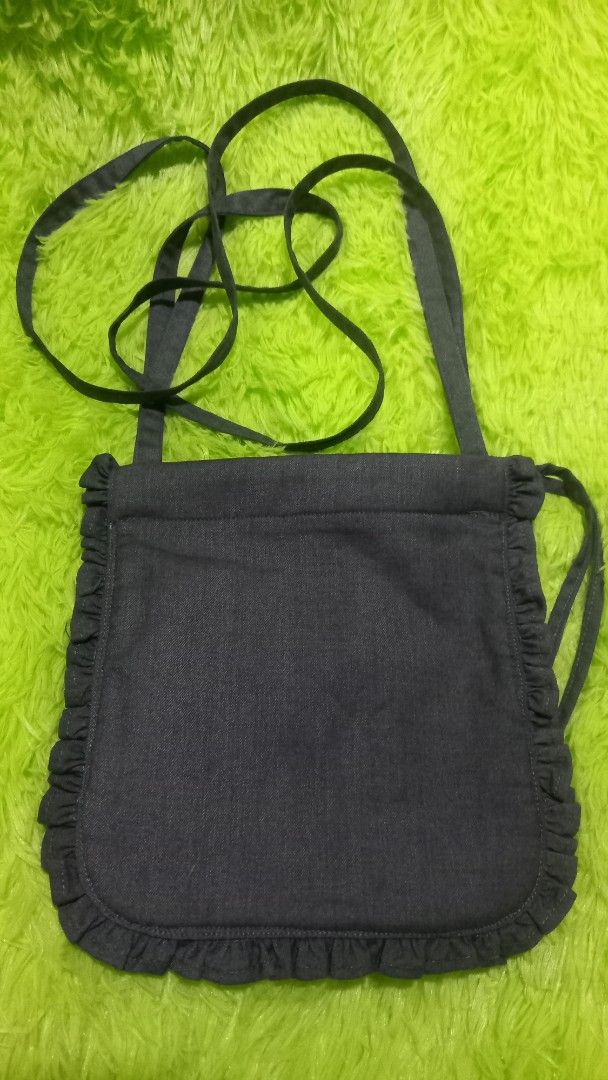 Dark Blue Ruffle Crossbody Bag (Category: Cross-body Bags) located in Manila. Submitted by twinklelyn03 (Listing ID 1421301527, Image 1). Description: - Dark blue fabric - Ruffle trim detail - Long crossbody strap - Simple, open interior - Small and stylish design - Ideal for carrying essentials see photos for details pm sa sure buyer only maraming salamat po!.