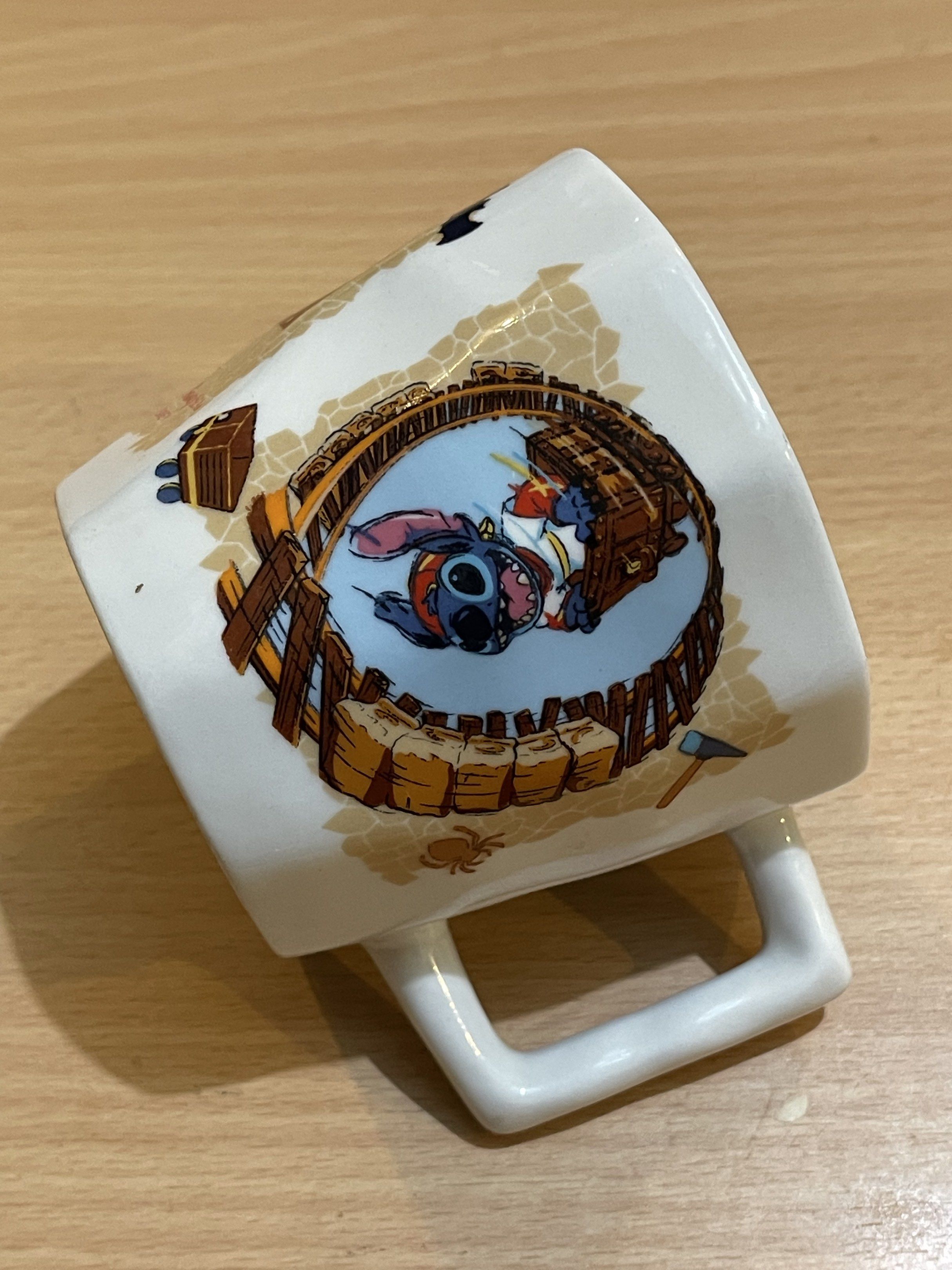 Disney Goofy and Stitch Mug (Category: Coffee & Tea Tableware) located in San Fernando. Submitted by japansurpluselyu (Listing ID 1421400848, Image 3). Description: - Disney Goofy and Stitch mug - Unique square handle - Features adventure-themed Goofy and Stitch illustrations - White mug with colorful design - Collectible item.