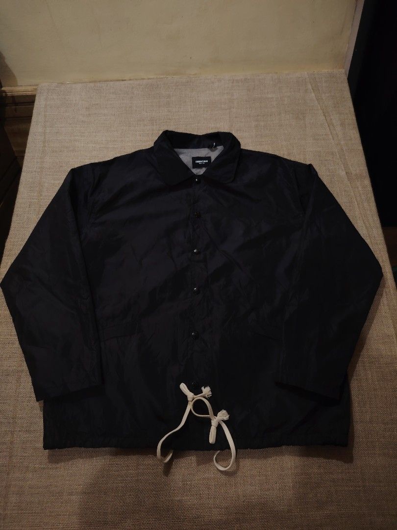 Essentials Coach Jacket Black (Category: Coats, Jackets and Outerwear) located in San Jose. Submitted by mickogapas67563 (Listing ID 1421332729, Image 1). Description: - Essentials black coach jacket - Size: Large - Features: - Button-up front - Collar - Drawstring hem - Back print: 'ESSENTIALS' in white - Material: 60% cotton - Lining: Gray.