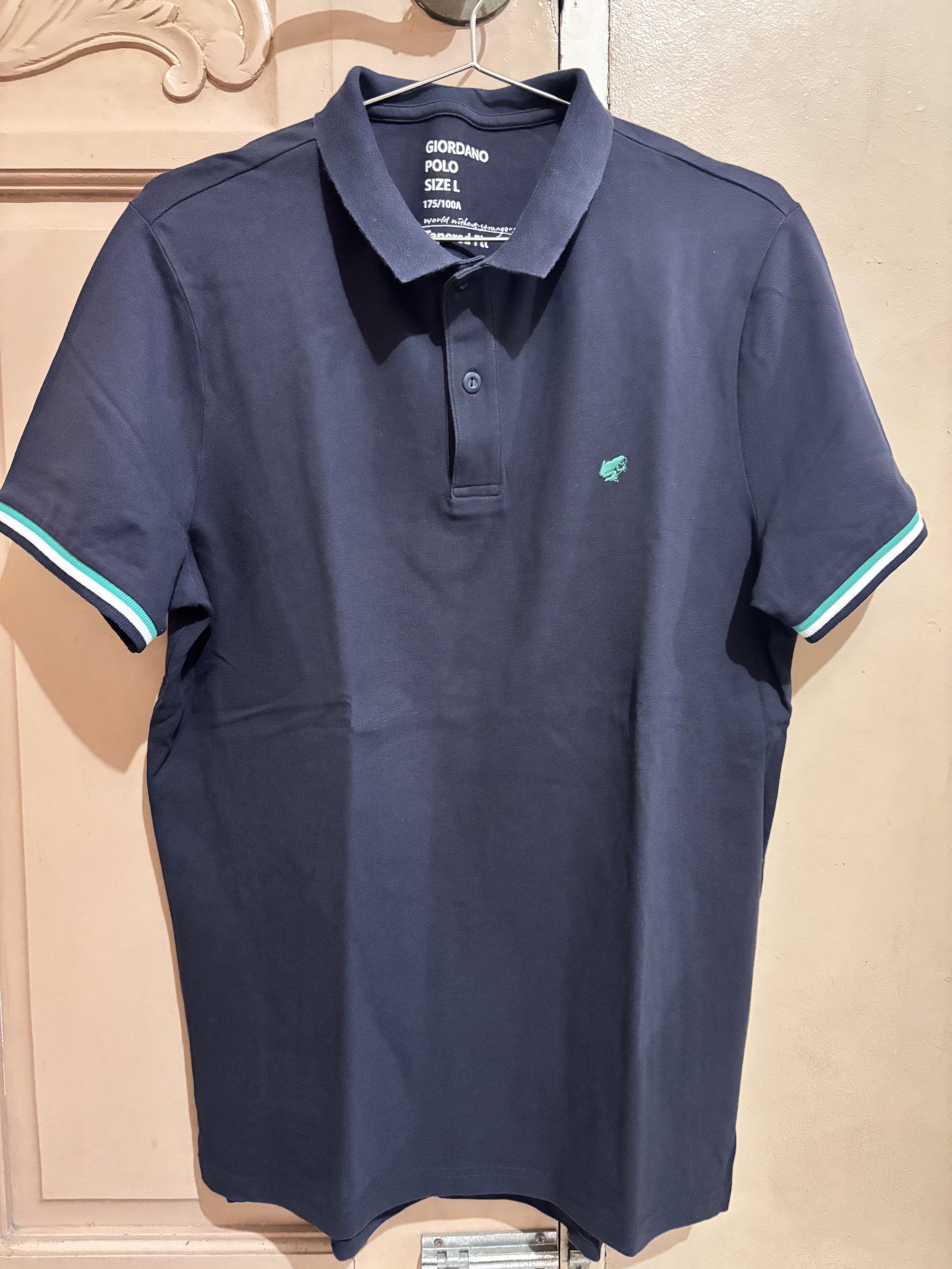 Giordano Polo Shirt - Size L (Category: Tshirts & Polo Shirts ) located in Concepcion. Submitted by cherishedthreads (Listing ID 1421318402, Image 1). Description: - Giordano navy blue polo shirt - Size: L (tapered fit) - Color: Navy blue - Features a green crocodile logo - Striped details on sleeves - Classic polo collar - Button closure - Comfortable fabric.