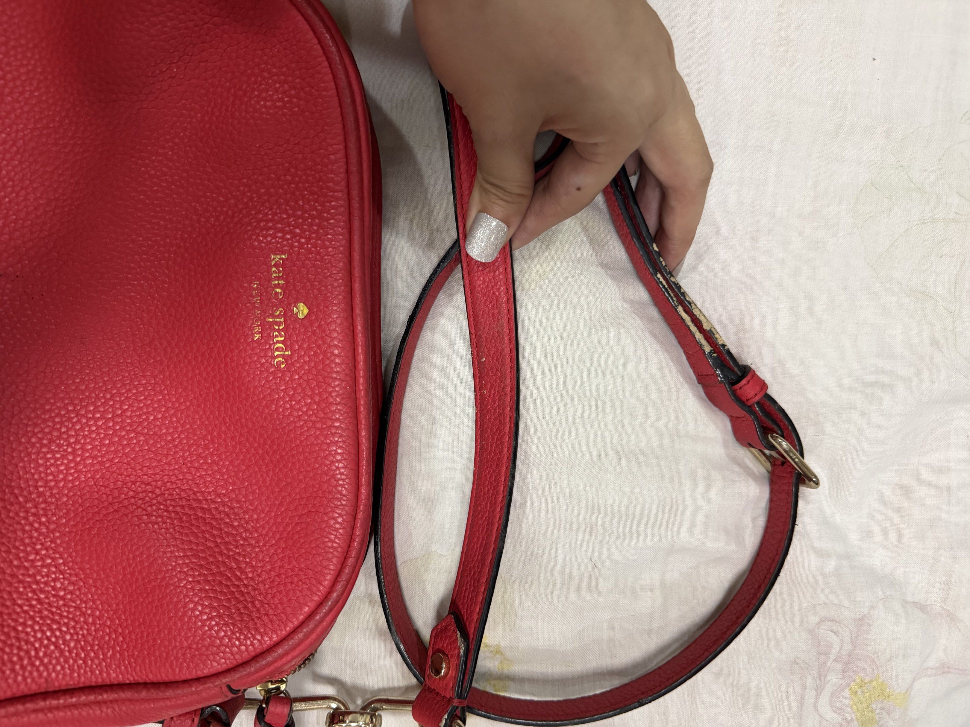 Kate Spade Red Crossbody Bag (Category: Cross-body Bags) located in Quezon City. Submitted by chasy9 (Listing ID 1421419385, Image 2). Description: - Authentic Kate Spade crossbody bag - Features a double-zippered main compartment and an adjustable strap - Includes a Kate Spade care card - The strap shows some wear, as shown in photo.