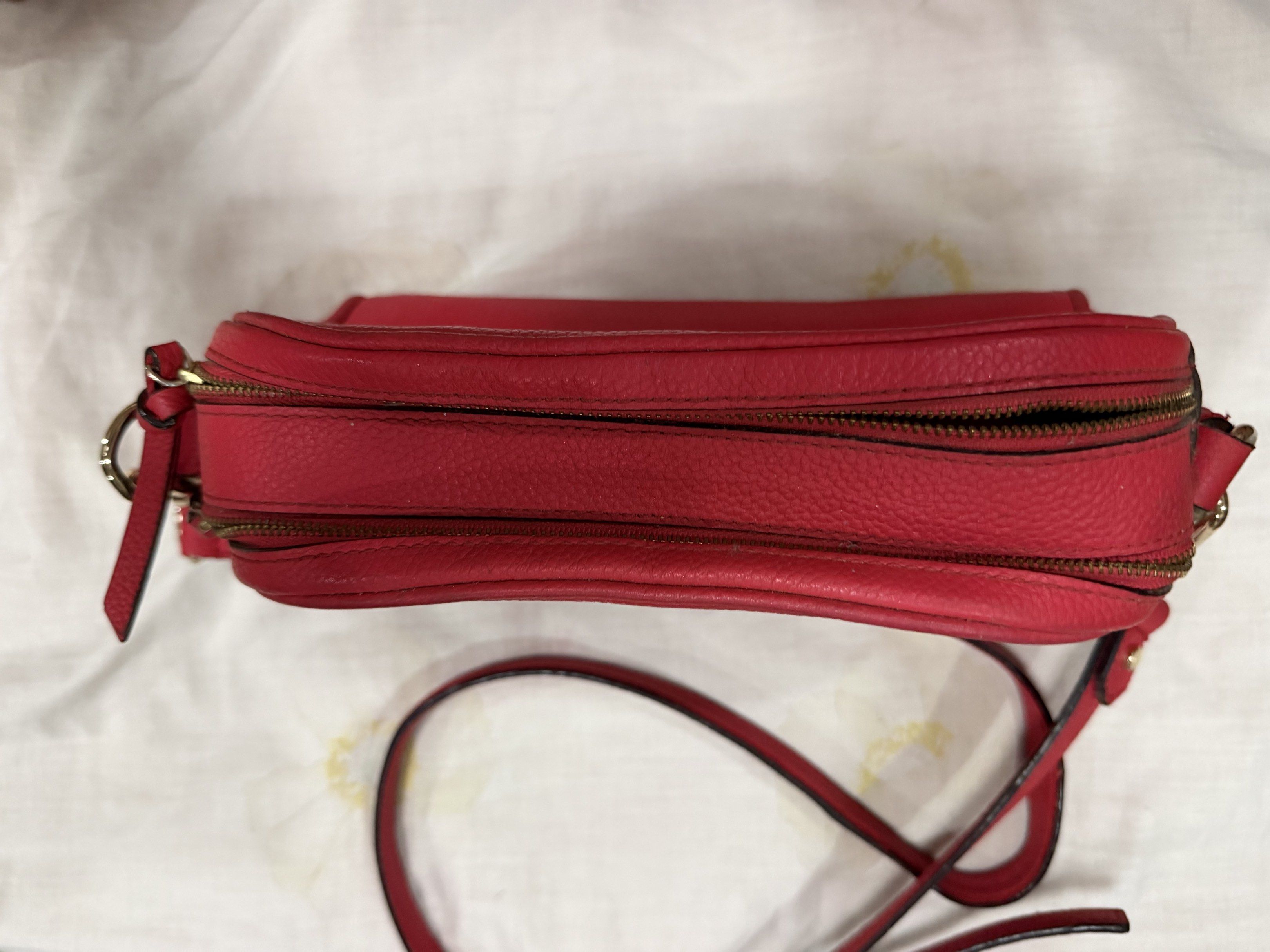 Kate Spade Red Crossbody Bag (Category: Cross-body Bags) located in Quezon City. Submitted by chasy9 (Listing ID 1421419385, Image 3). Description: - Authentic Kate Spade crossbody bag - Features a double-zippered main compartment and an adjustable strap - Includes a Kate Spade care card - The strap shows some wear, as shown in photo.