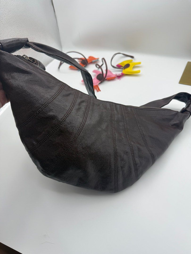 Lemaire dark maroon Bag (Category: Luxury Bags & Wallets) located in Caloocan City. Submitted by rossvault2 (Listing ID 1421328639, Image 3). Description: - Lemaire shoulder bag -coated canvass - Unique crescent shape with stitched detailing - Single shoulder strap - Secure zip closure - Interior pocket - Includes brand label - Made in Spain With washtag Normal signs of use pls check photos.
