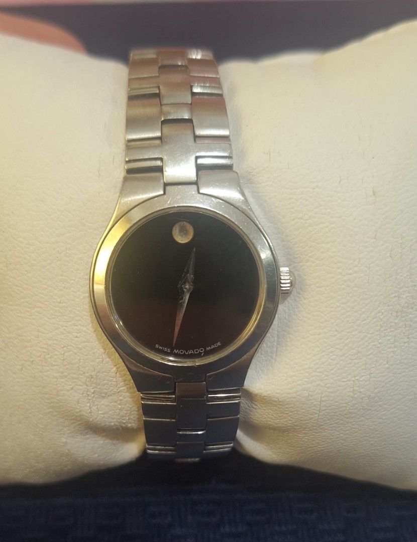 Movado Swiss Made Watch (Category: Women's Watches) located in Manila. Submitted by cor1024 (Listing ID 1421326617, Image 2). Description: - Movado watch - Black dial - Silver-tone stainless steel bracelet - Minimalist design - Single dot at 12 o'clock - Round face - Secure clasp - Swiss made.