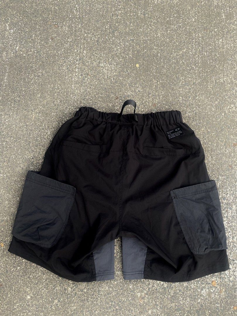 Oakley Software Black Cargo Utility Shorts XL (Category: Shorts) located in General Trias. Submitted by tuffstuff13 (Listing ID 1421389474, Image 2). Description: - Width (Elastic waistband/free waist) - Length 19 - Black Oakley software cargo utility shorts (XL) - Durable, textured fabric - Multiple pockets for storage - Built-in belt and elastic waistband for comfort - Button closure and drawstring - Unique design with overlapping panels - Oakl