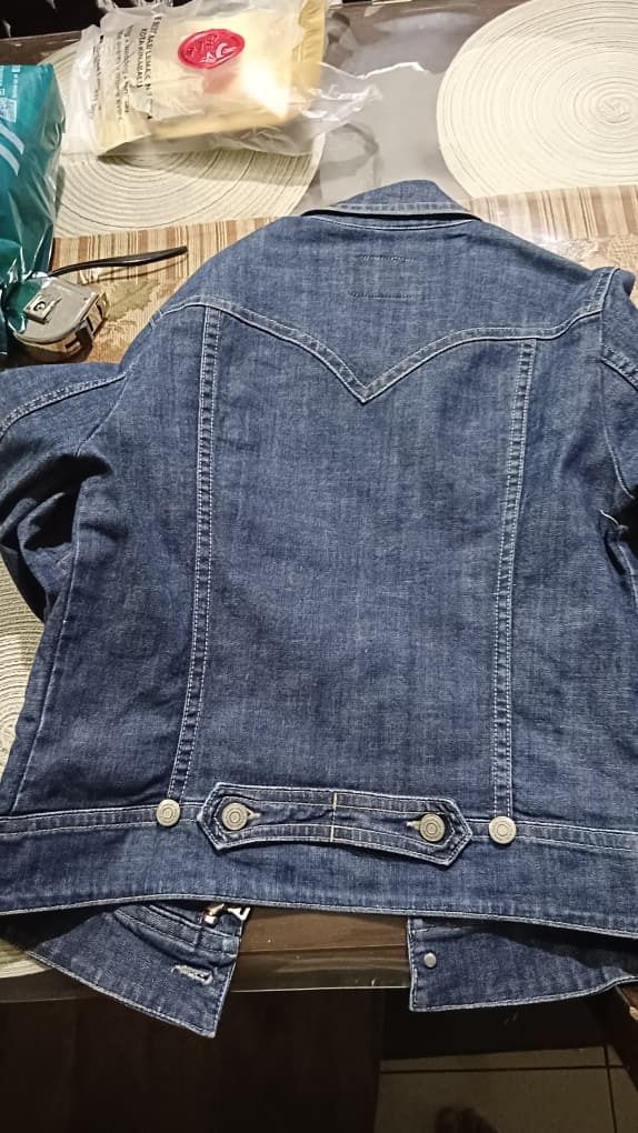 Polham Denim Jacket (Category: Coats, Jackets and Outerwear) located in Kota Kinabalu. Submitted by errduhh (Listing ID 1421351621, Image 3). Description: pit - 19 labuh - 25 - Polham denim jacket - Classic design - Button closures - Multiple pockets - Red stripe detail - Standard fit - Suitable for casual wear - Made of denim.