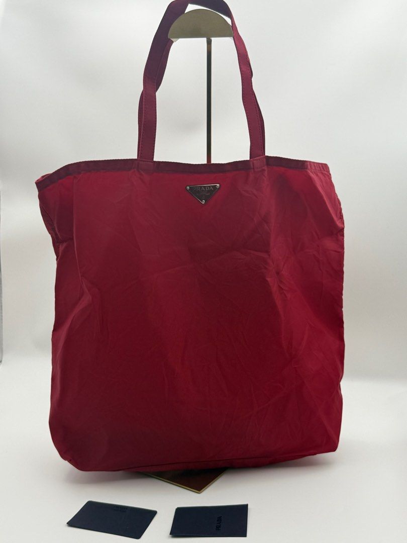 Prada Robot Motif Tote Bag (Category: Luxury Bags & Wallets) located in Caloocan City. Submitted by rossvault2 (Listing ID 1421325023, Image 2). Description: Red Prada tote bag featuring a robot motif on the front. It has a top zipper closure and a small Prada logo on the front. The bag includes a small Prada logo tag inside. The bag has double handles for carrying. -lampo zip -card included -pls check photos for issue.