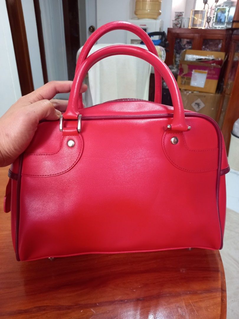 Red Handbag with Lion Logo (Category: Tote Bags) located in Manila. Submitted by zenphoenix-7ad615 (Listing ID 1421367313, Image 3). Description: - Red handbag - Lion logo detail - Top handle - Zip closure - Black interior with red tag - Smooth material - Rectangular shape - Side zip pocket.