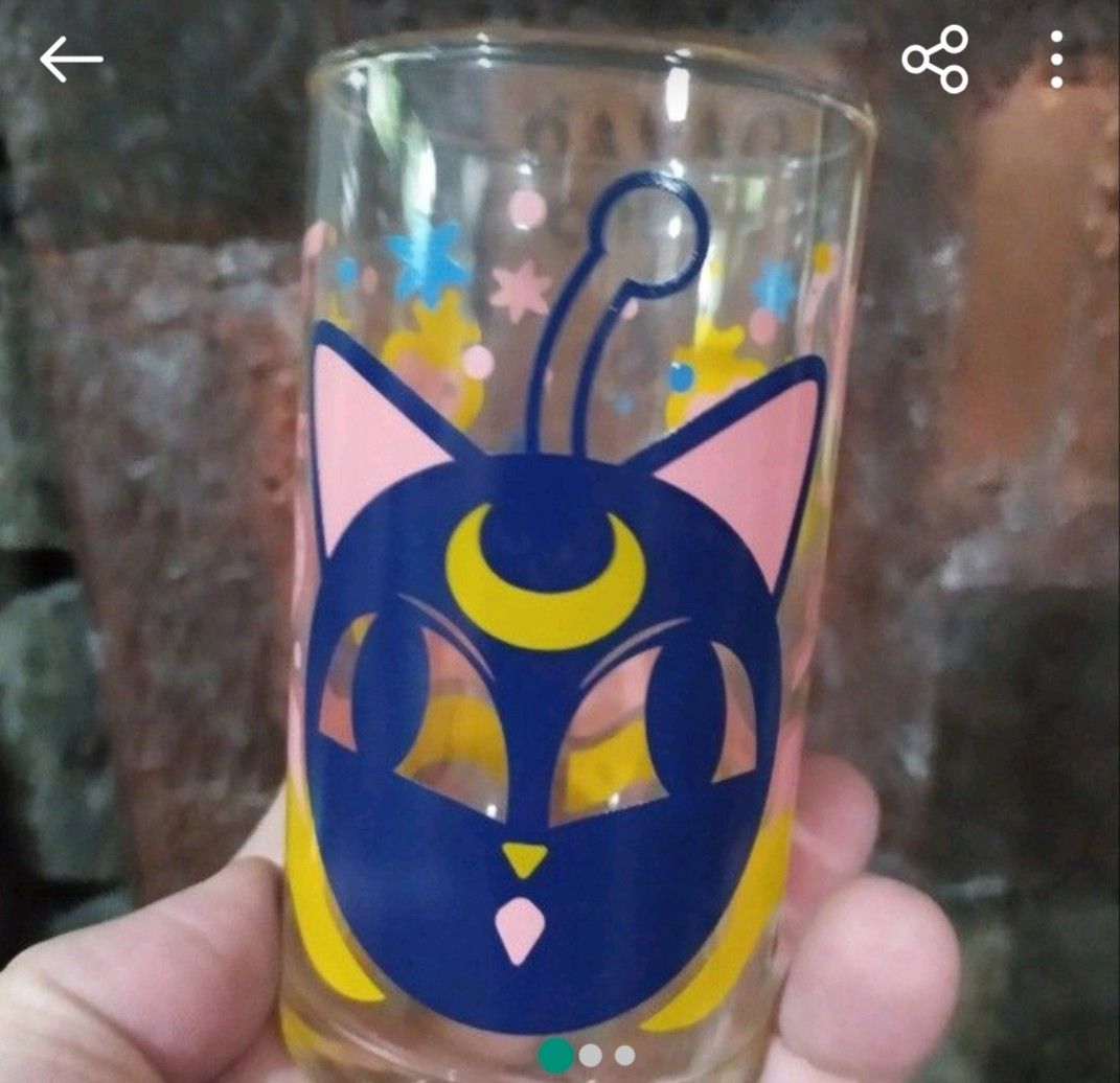 Sailor Moon Glass (Category: Dinnerware & Cutlery) located in Caloocan City. Submitted by toys_r_here (Listing ID 1421380230, Image 1). Description: - Sailor Moon themed glass. - Features a blue cat face with a crescent moon. - Includes other Sailor Moon character designs. - Clear glass with colorful graphics..