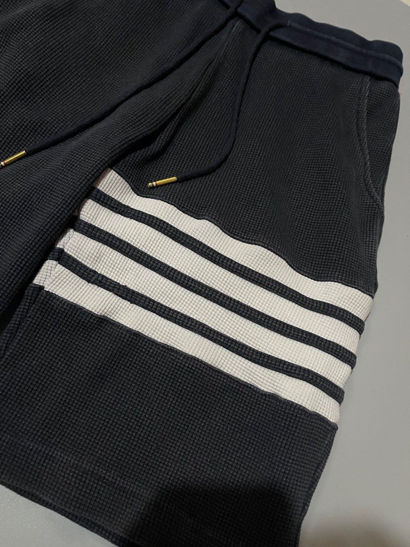 Thom Browne Waffle Knit Shorts (Category: Luxury Apparel) located in Angeles City. Submitted by andreiboughts (Listing ID 1421294889, Image 3). Description: Length: 21 Waist: 26-34 MAX (Garterized) - Authentic Thom Browne shorts - Made in Japan - Black waffle knit fabric - Signature white stripes on the side - Drawstring waist with gold-toned hardware - Thom Browne label visible - Size 1 - Navy blue waistband with red and white stripes.