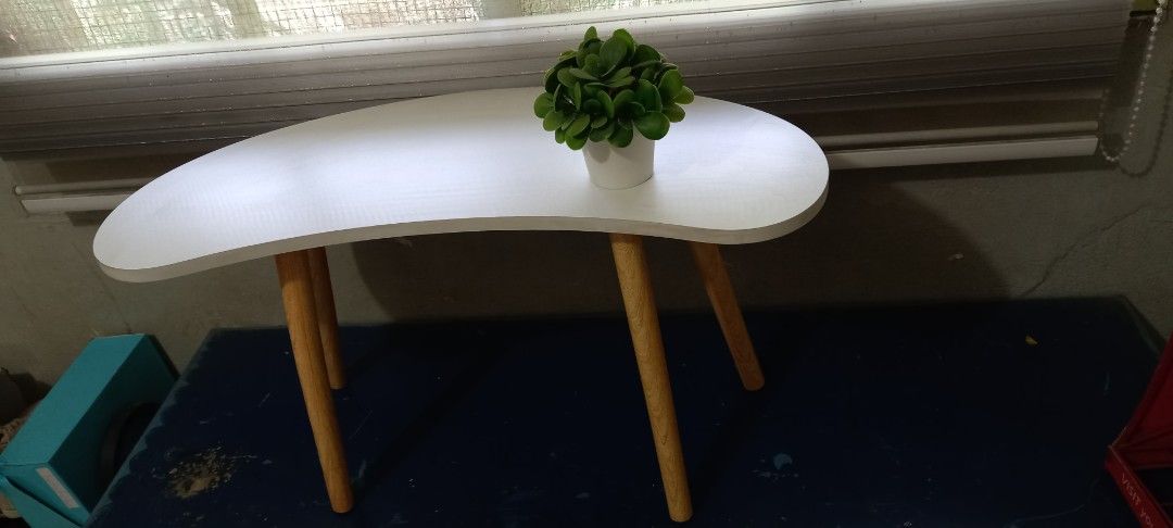 White Coffee Table with Wooden Legs (Category: Tables & Sets) located in Taytay. Submitted by decluttering_is_fun_by_dr_a (Listing ID 1421300475, Image 1). Description: - Stylish white coffee table - Unique curved design - Sturdy wooden legs - Perfect for small spaces - Ideal for drinks, books, and plants - Adds a decorative touch to any room H-42, L -76, w-30 po.