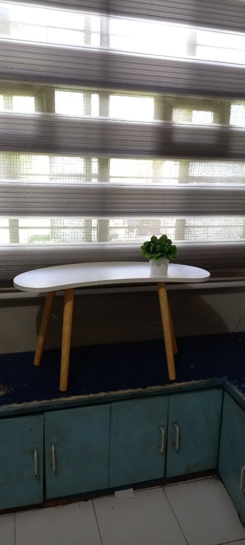 White Coffee Table with Wooden Legs (Category: Tables & Sets) located in Taytay. Submitted by decluttering_is_fun_by_dr_a (Listing ID 1421300475, Image 3). Description: - Stylish white coffee table - Unique curved design - Sturdy wooden legs - Perfect for small spaces - Ideal for drinks, books, and plants - Adds a decorative touch to any room H-42, L -76, w-30 po.