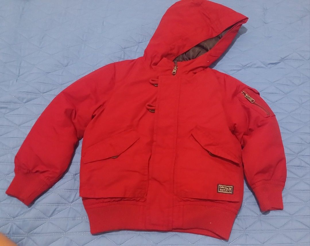 Zara Boys Red Winter Jacket with Hood (Category: Babies & Kids Fashion) located in Urbiztondo. Submitted by owiesreyes (Listing ID 1421397785, Image 1). Description: - Zara Boys Red Winter jacket - Size: 4/5 (110) - Features: Hood, zipper closure, front pockets, sleeve pocket - Design: Ribbed hem and cuffs - Made in Bangladesh - Perfect for your child's outerwear needs.