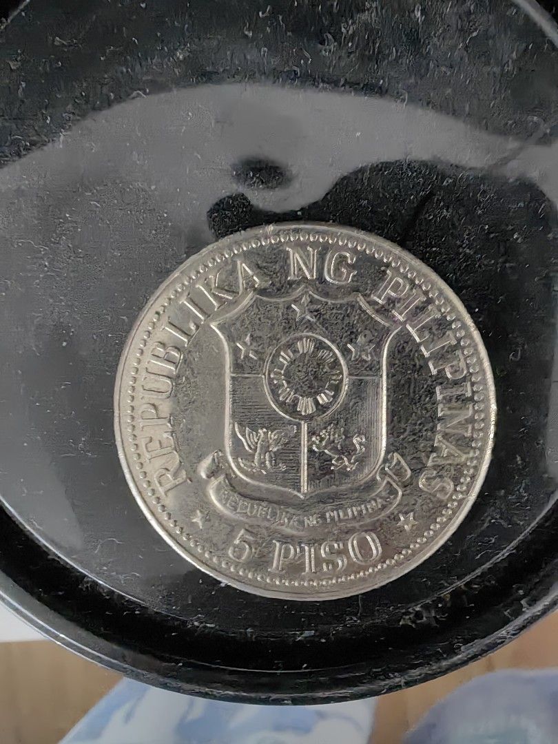 1975 5 Piso Coin (Category: Currency) located in Davao. Submitted by ee2006 (Listing ID 1421618673, Image 2). Description: - 1975 5 Piso coin from the Philippines. - Obverse: Features "ANG BAGONG LIPUNAN" and Ferdinand E. Marcos. - Reverse: Shows the Philippine coat of arms and "REPUBLIKA NG PILIPINAS"..
