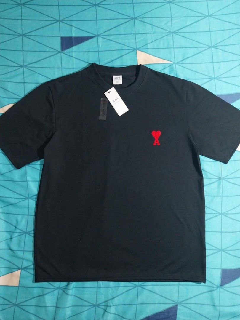 AMI Paris Black T-shirt (Category: Tshirts & Polo Shirts ) located in Baguio. Submitted by aertssss (Listing ID 1421605969, Image 1). Description: - Brand: AMI Paris - Color: Black shirt with red heart logo - Features: Crew neck, short sleeves - Condition: Brand new with original tag - Material: Lightweight fabric.