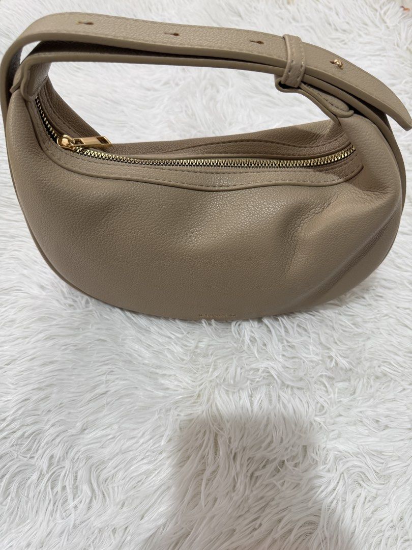 BOSTANTEN Crescent Bag (Category: Shoulder Bags) located in Cavite. Submitted by 0825cherry (Listing ID 1421472848, Image 1). Description: - BOSTANTEN crescent handbag - Stylish design - Top handle - Secure zippered closure - Textured material - Gold-toned zipper - Features the BOSTANTEN logo - Neutral color, versatile for various outfits.
