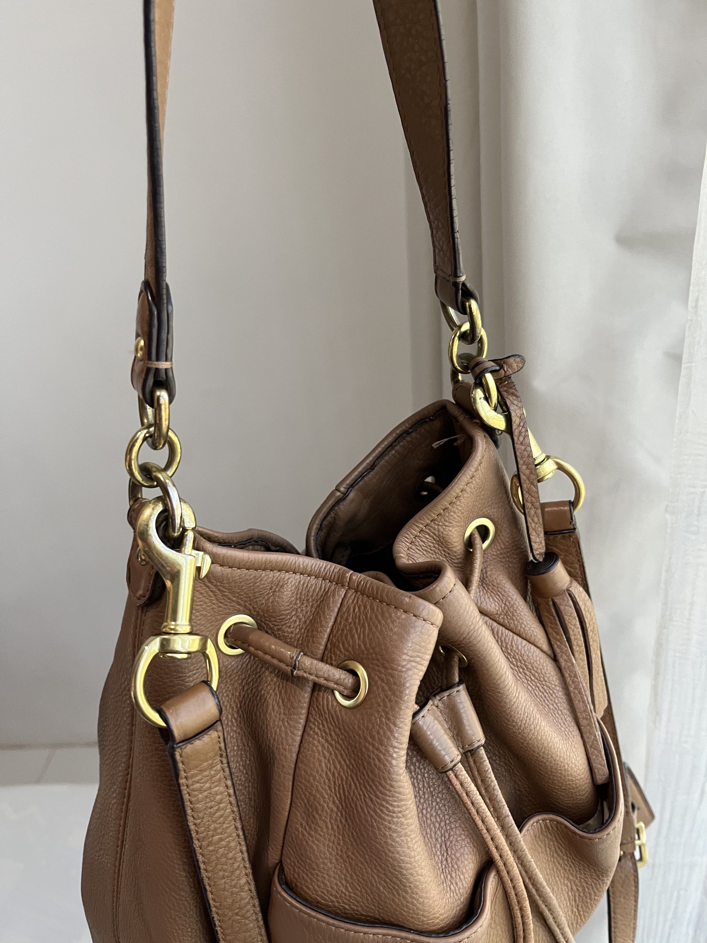 Coach Avery Leather Drawstring Bucket Bag (Category: Luxury Bags & Wallets) located in Bacolod City. Submitted by gin.knee (Listing ID 1421490151, Image 2). Description: - Coach drawstring bucket bag - Brown color - Drawstring closure - Adjustable shoulder strap - Exterior pocket - Interior zippered pocket - Gold-tone hardware ❌ With fading on hardware.