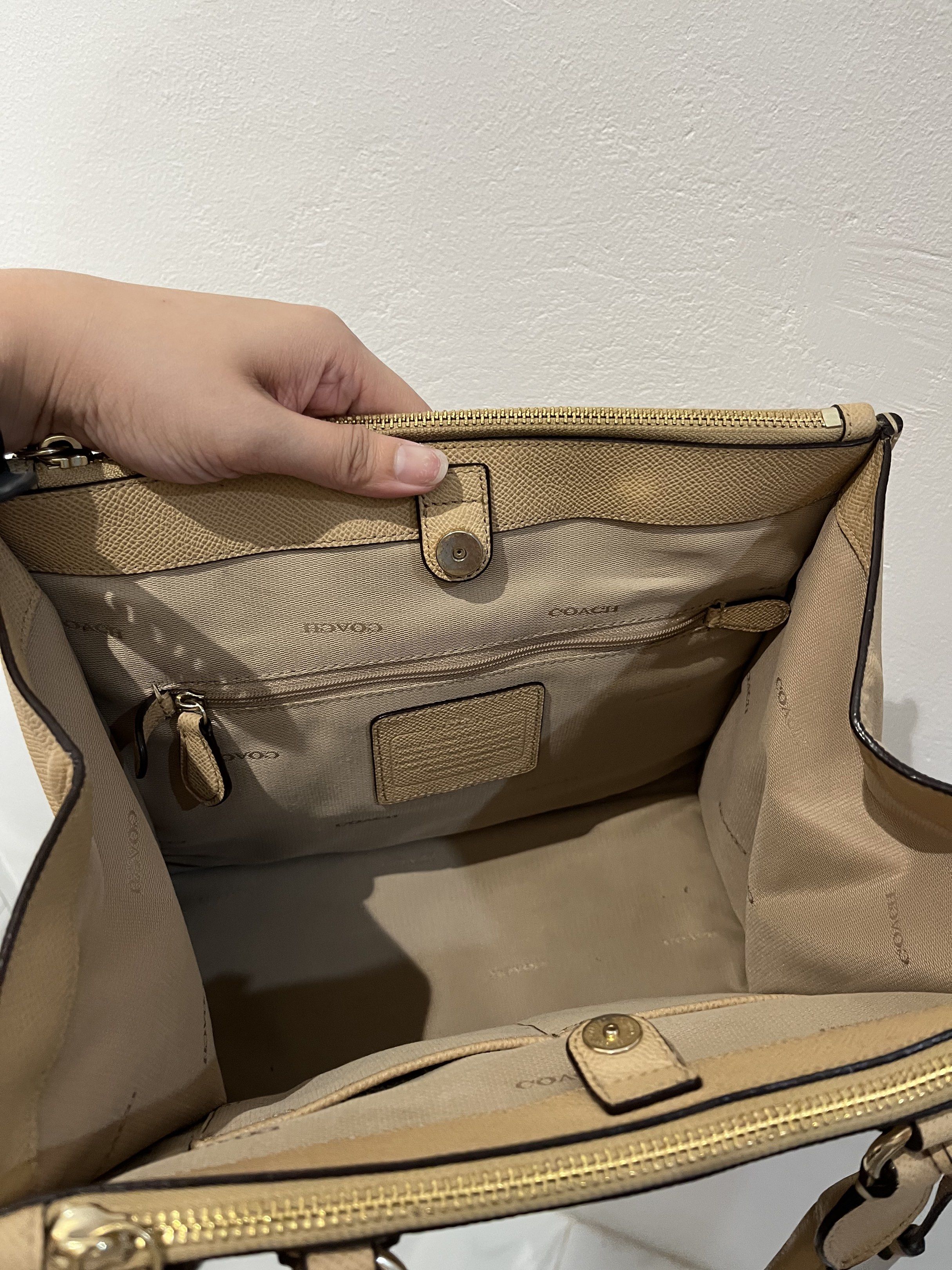 Coach Beige Crosby Carryall Bag (Category: Luxury Bags & Wallets) located in Bacolod City. Submitted by gin.knee (Listing ID 1421490372, Image 3). Description: - Beige leather Coach tote bag - Top handle design - Detachable tag included - Secure zip closure - Includes a shoulder strap - Multiple interior compartments - Classic and versatile style.