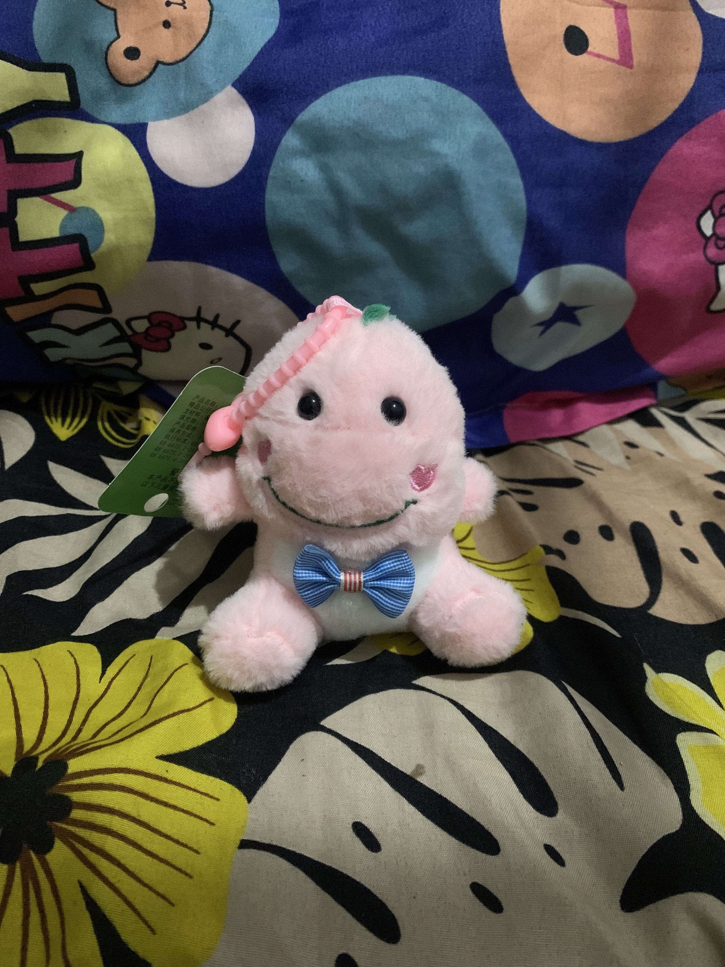 Pink Dinosaur Plush Keychain (Category: Plushies & Soft Toys) located in San Juan, La Union. Submitted by declutteringog7 (Listing ID 1421560959, Image 2). Description: - Adorable pink dinosaur plush keychain - Features a cute blue bow tie and smiling face - Comes with a tag - Perfect for keys, bags, or backpacks - A charming and huggable companion.