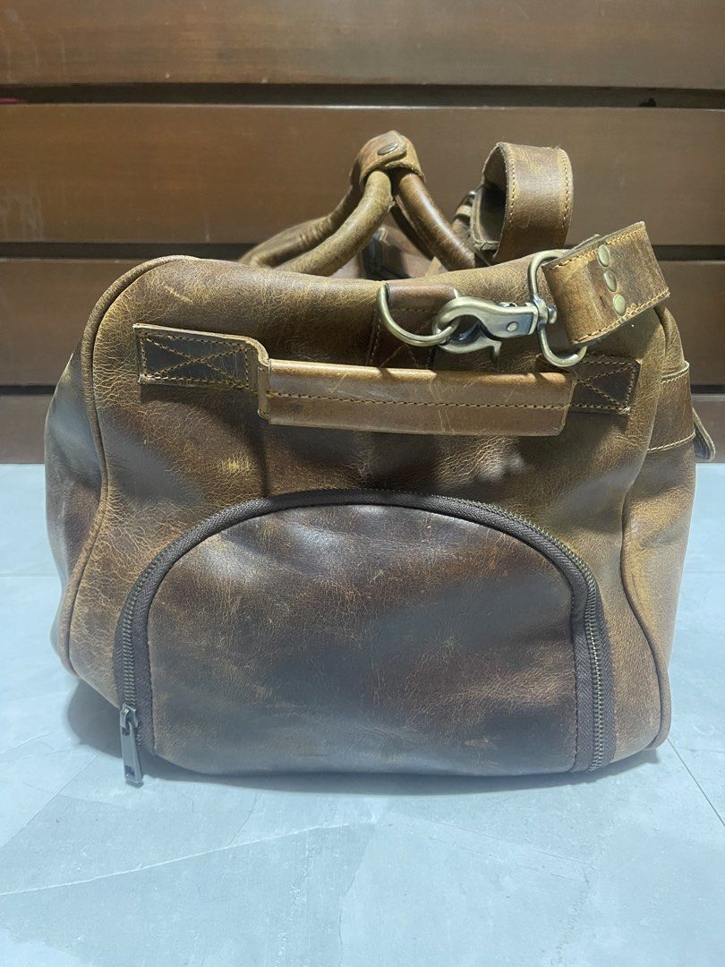 Kodiak 60L Weekender Duffle Bag - Antique Brown (Category: Luxury Bags & Wallets) located in Bacnotan. Submitted by anosellmo (Listing ID 1421561497, Image 3). Description: - Genuine leather 60L weekender duffle bag - Antique brown color - Spacious main compartment - Side pockets for extra storage - Secure zipper closure - Detachable shoulder strap - Ideal for weekend getaways and travel - Classic, rugged look - Missing kisslock on front pocket.