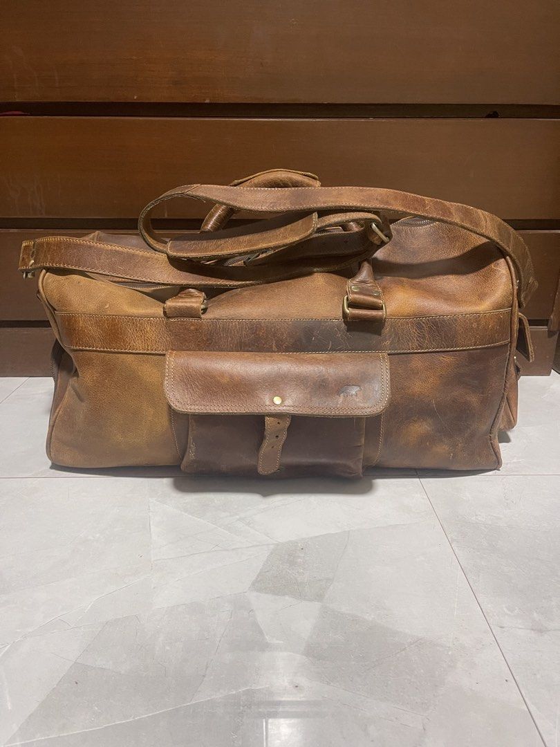 Kodiak 60L Weekender Duffle Bag - Antique Brown (Category: Luxury Bags & Wallets) located in Bacnotan. Submitted by anosellmo (Listing ID 1421561497, Image 1). Description: - Genuine leather 60L weekender duffle bag - Antique brown color - Spacious main compartment - Side pockets for extra storage - Secure zipper closure - Detachable shoulder strap - Ideal for weekend getaways and travel - Classic, rugged look - Missing kisslock on front pocket.
