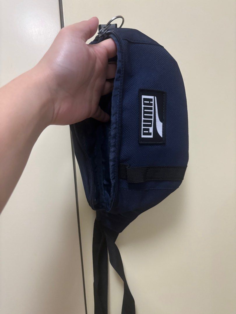 Puma Waist Bag (Category: Belt bags, Clutches and Pouches) located in Manila. Submitted by jrlua (Listing ID 1421565450, Image 2). Description: Navy blue Puma waist bag. Features a main compartment with a zipper closure and an internal pocket. Includes an adjustable strap. The Puma logo is visible on the front. .