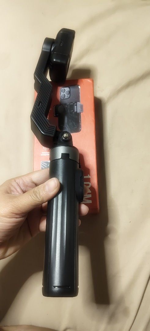 Q31 1.0M Gimbal Stabilizer (Category: Gimbals & Stabilizers ) located in Malabon City. Submitted by granmerlencagayandeoro (Listing ID 1421612485, Image 2). Description: - Q31 1.0M Gimbal Stabilizer - Black color - Includes original box - Features a handle for easy grip - Comes with a phone holder - Perfect for creating stable videos with your phone.