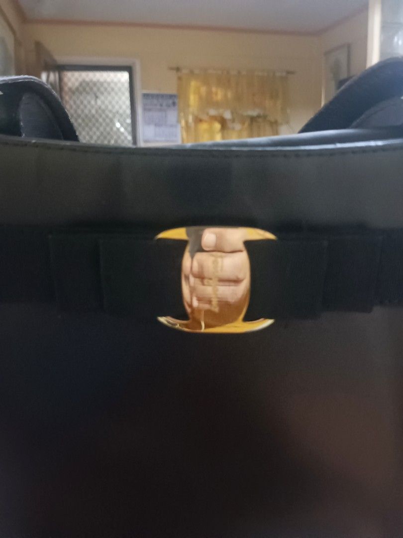 Salvatore Ferragamo Black Leather Handbag (Category: Luxury Bags & Wallets) located in Bacoor. Submitted by mms123mms (Listing ID 1421520583, Image 2). Description: - Black leather handbag - Gold-tone bow detail - Top handle design - Snap closure - Smooth leather - Rectangular shape.