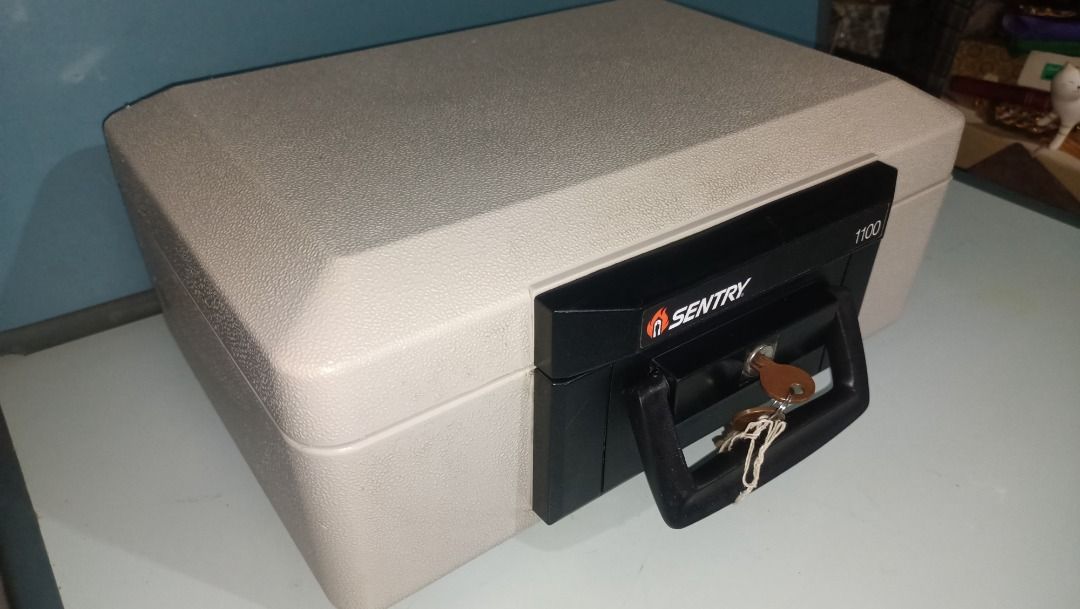 Sentry 1100 Fire Safe Box (Category: Safe) located in Munoz. Submitted by larryc1212 (Listing ID 1421577159, Image 2). Description: Sentry 1100 fire safe box. Includes keys. The safe has a black handle and lock area. The interior is light gray. The safe has a label indicating it is classified by Underwriters Laboratories Inc. as to fire resistance. The safe measures approximately 14 inches wide. Item may include some scratches due to age, as is w