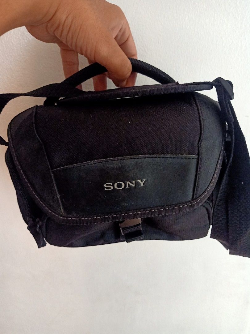 Sony Camera Bag (Category: Camera Bags & Carriers) located in Las Pinas. Submitted by the_recycle_shop (Listing ID 1421466269, Image 1). Description: - Black Sony camera bag - Includes handle and shoulder strap - Main compartment with padded dividers - Front flap with buckle closure - Features Sony logo - Made of durable fabric - Light-colored interior lining.
