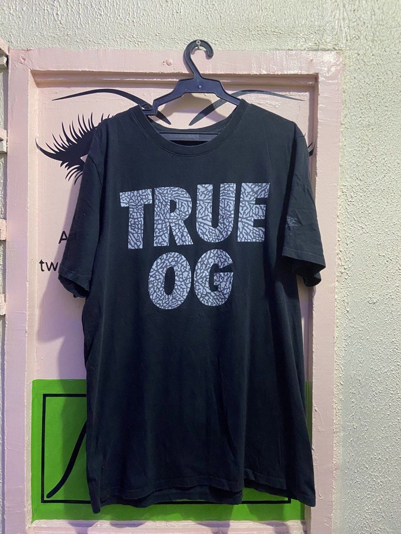 True OG Graphic Tee (Category: Tshirts & Polo Shirts ) located in Manila. Submitted by vjalejandr35483 (Listing ID 1421582188, Image 1). Description: - Black crew neck t-shirt - Features "TRUE OG" graphic print - Print design includes a grey elephant pattern within the letters.