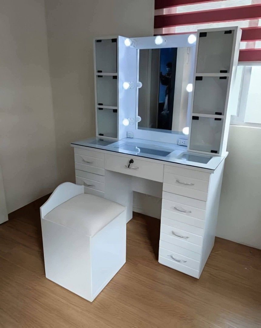 Vanity Table with Mirror and Lights (Category: Tables & Sets) located in Mabalacat. Submitted by arlenemamangun01 (Listing ID 1421568325, Image 3). Description: - White vanity table with large mirror and built-in lights - Multiple drawers and side cabinets with glass shelves - Includes matching stool - Sleek design - Ample storage space - Ideal for makeup and beauty routines.