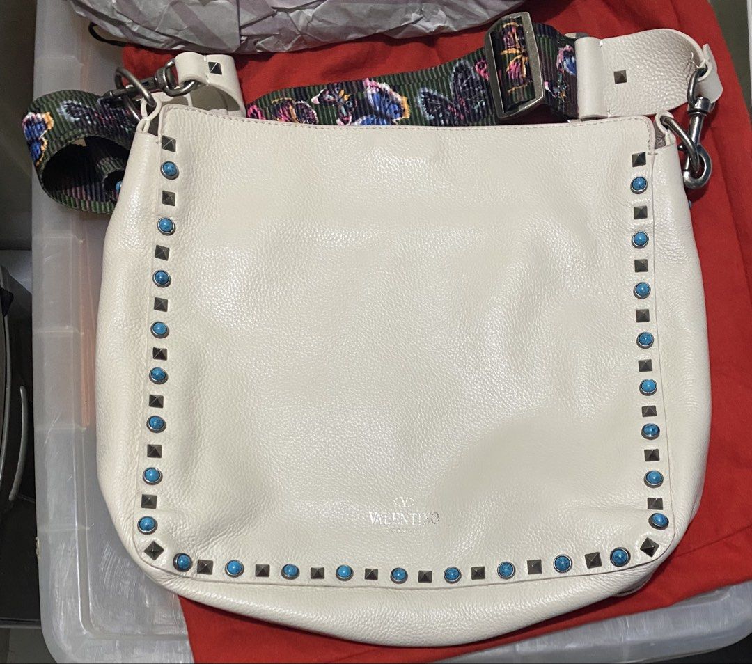 White leather Rockstud Hobo Bag (Category: Shoulder Bags) located in Pasig City. Submitted by getstuffph (Listing ID 1421561556, Image 2). Description: - Cream color with turquoise studs - Patterned shoulder strap - Silver-tone hardware - Includes dust bag.