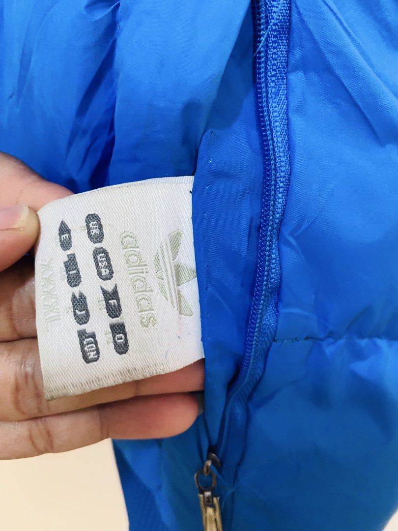 Adidas Reversible Puffer Vest Medium (Category: Vests) located in Santiago. Submitted by mfdthriftstore (Listing ID 1421686756, Image 3). Description: - Adidas reversible puffer vest - Size: Medium - Colors: Blue (exterior) / Grey patterned (interior) - Features: Hood, full-length zipper - Adidas logo on chest and hood - Condition: Excellent.