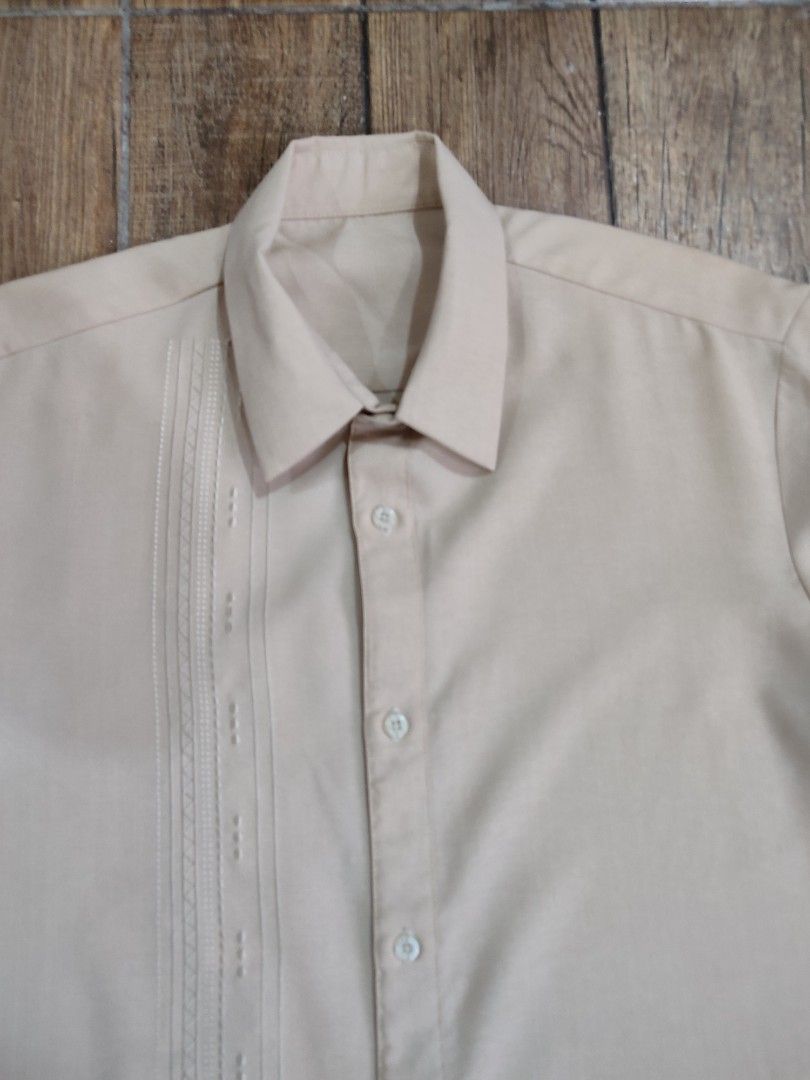 Beige Short Sleeve Shirt (Category: Shirts) located in Dasmarinas. Submitted by sbtt_ (Listing ID 1421639559, Image 1). Description: - Beige short sleeve shirt - Classic collar and button-down closure - Decorative pleats on left chest - Smooth, possibly synthetic fabric - Suitable for casual and semi-formal occasions.