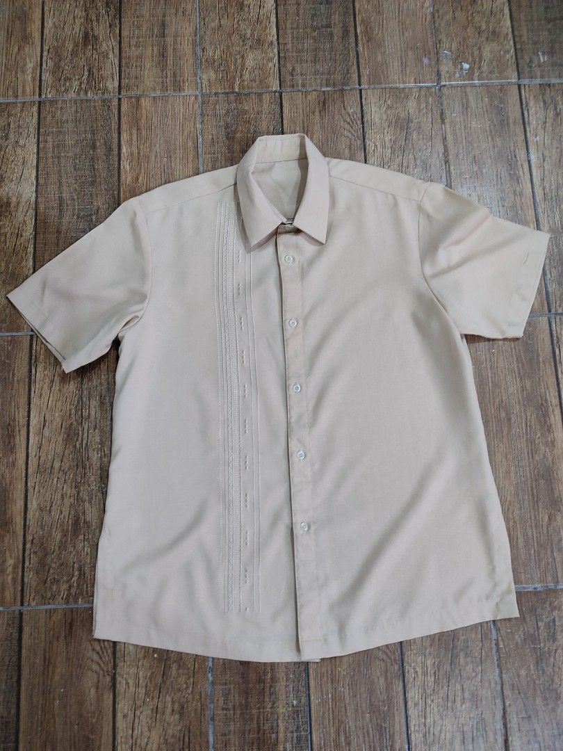 Beige Short Sleeve Shirt (Category: Shirts) located in Dasmarinas. Submitted by sbtt_ (Listing ID 1421639559, Image 2). Description: - Beige short sleeve shirt - Classic collar and button-down closure - Decorative pleats on left chest - Smooth, possibly synthetic fabric - Suitable for casual and semi-formal occasions.