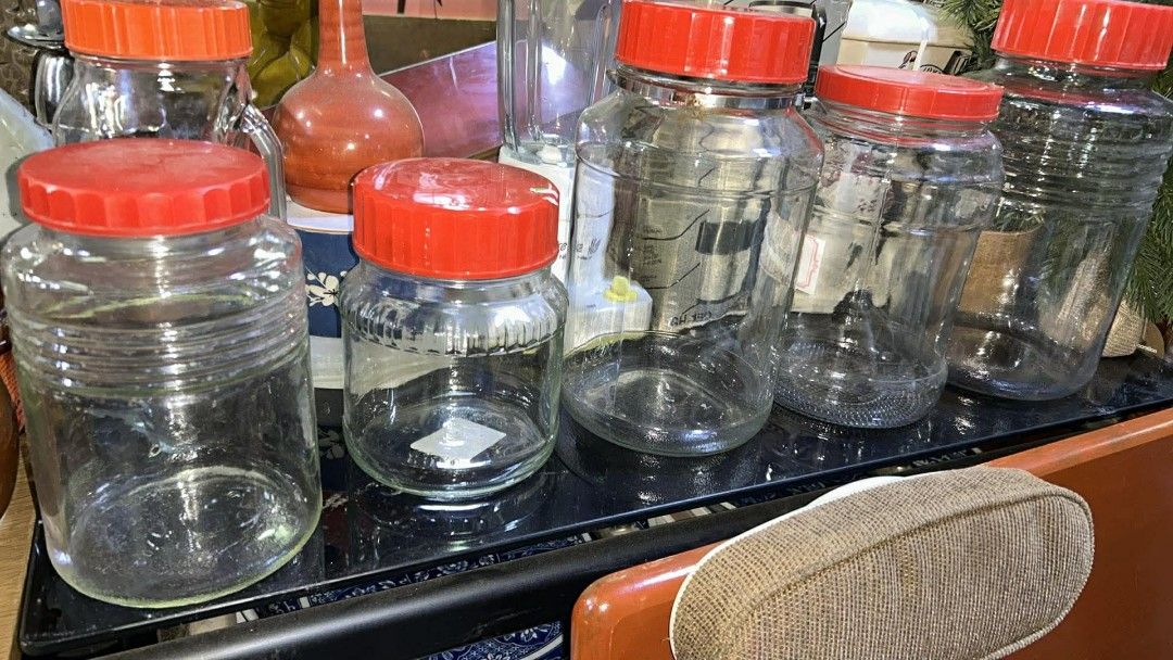 BIG IMPORTED CLEAR GLASS JARS W/ LIDS (Category: Food Organization & Storage) located in Valenzuela. Submitted by gregferraren (Listing ID 1421741841, Image 2). Description: big glass jars with red lids. Various sizes available, perfect for storage or display. Some jars have ribbed designs, while others are smooth. One jar has a metal clasp. Great for kitchen organization or as decorative pieces. These jars are sturdy and well-made, offering a cl