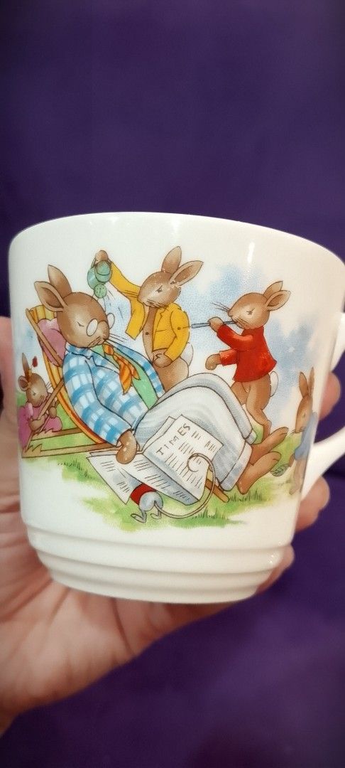 Bunnykins English Fine Bone China Cup (Category: Dinnerware & Cutlery) located in Cabanatuan. Submitted by miss.maia (Listing ID 1421760031, Image 2). Description: - Charming Bunnykins cup with rabbit illustrations. - Made from English Fine Bone China. - Features a classic curved handle. - White base with colorful artwork. - Interior rim has a border of running rabbits. - Marked with the Bunnykins logo..